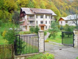 a large house with a gate in front of it at Pension Casa Alba in Slănic-Moldova
