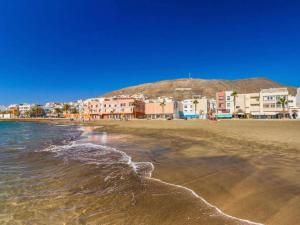 a beach with a group of buildings and the ocean at Lola in Gran Tarajal