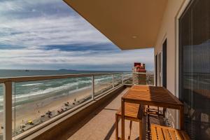 a balcony with a table and a view of the beach at Rosarito Beach Luxury Beachfront Walk 2 Papas & Beer in Rosarito