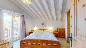 a bedroom with a bed and a large window at Polaschin A8 in Sils Maria