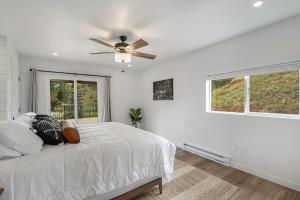 a white bedroom with a bed and a ceiling fan at Welcome! 4 bedroom (6 bed) 3 bath River House 