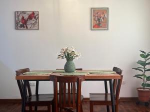 einen Esstisch mit einer Blumenvase darauf in der Unterkunft San Miguel, precioso depa 3 camas, internet y cable in Lima