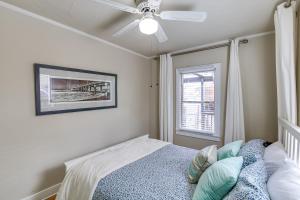 a bedroom with a bed with a ceiling fan and a window at Charming Bungalow Near LA Waterfront and Beaches in San Pedro