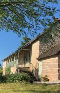 un antiguo edificio de ladrillo con escaleras en un campo en Rudelle maison de vacances en Rudelle