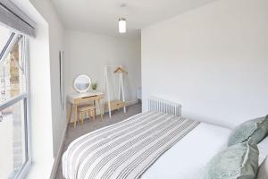 a white bedroom with a bed and a desk at Panoramic Seaview 1 Bedroom Stylish Apartment in Redcar