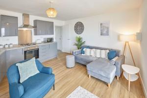 a living room with a couch and chairs and a kitchen at Panoramic Seaview 1 Bedroom Stylish Apartment in Redcar