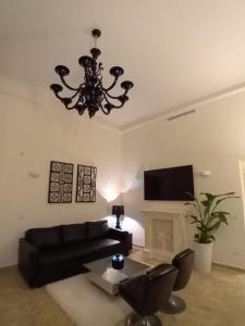 een woonkamer met een zwarte bank en een kroonluchter bij Bari Downtown Luxury Apartment in Bari