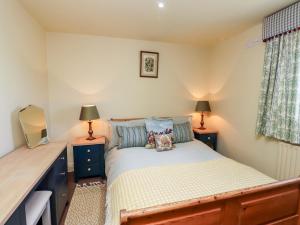 a small bedroom with a bed and two lamps at The Byre in Morpeth