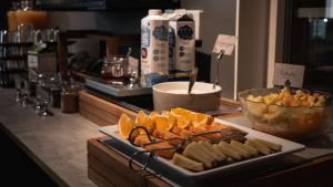 a buffet with a plate of cheese and a bowl of fruit at Hotell Boras, BW Signature Collection in Borås