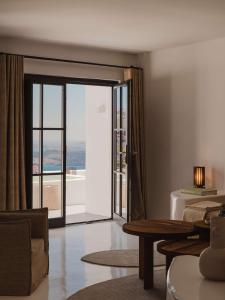 a living room with a large sliding glass door at Nobu Hotel Santorini in Imerovigli