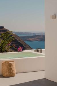 a wicker basket sitting on a white wall with a view at Nobu Hotel Santorini in Imerovigli