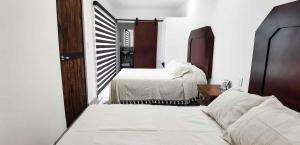 een slaapkamer met 2 bedden en een spiegel bij Vagón Resort in Cuatrociénegas de Carranza