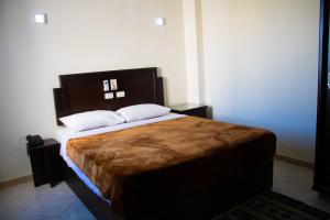 a bedroom with a large bed with a wooden headboard at Sharks Bay Oasis Resort & Butterfly Diving Center in Sharm El Sheikh