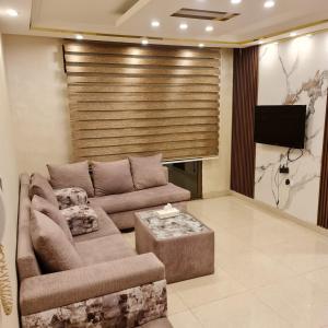 a living room with a couch and a flat screen tv at Quadro apartment in Amman
