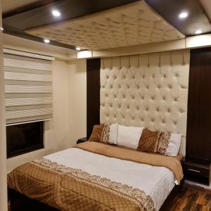 a bedroom with a large bed with a large headboard at Quadro apartment in Amman