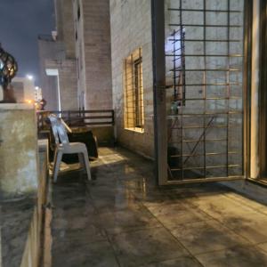 a white chair sitting on top of a patio at Quadro apartment in Amman