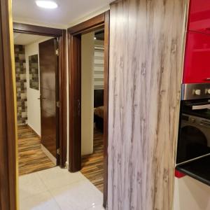 a kitchen with red cabinets and a wooden wall at Quadro apartment in Amman