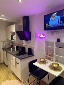 a kitchen with a table and a tv on the wall at Honey Room22 , parking, proche gare in Saint-Brieuc