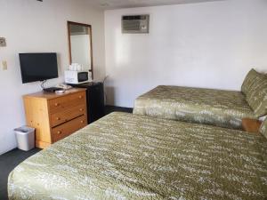 a hotel room with two beds and a television at Budget Inn Durango in Durango