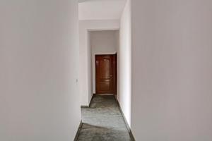 an empty corridor with a door in a building at OYO Omi Guest House in Gurgaon