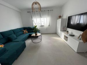 a living room with a blue couch and a refrigerator at Lola in Gran Tarajal