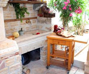 uma cozinha em pedra com um lavatório e uma mesa em Casa Bellavista em Banjole