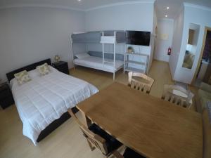 1 dormitorio con cama, mesa y comedor en Studios by Blue Door, en Portimão