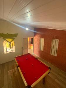 una mesa de billar roja en una habitación con una pared de ladrillo en recanto Gonzales, en Sarapuí