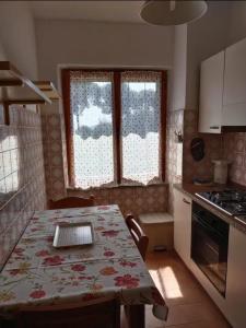 une cuisine avec une table et un tissu de table fleuri dans l'établissement Casa Giannella, a due passi dal mare, à Giannella
