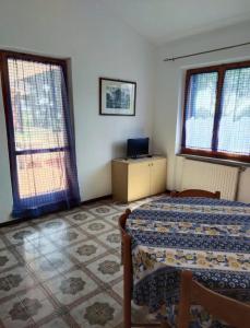 - une chambre avec un lit, une table et deux fenêtres dans l'établissement Casa Giannella, a due passi dal mare, à Giannella