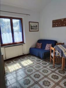 - un salon avec un canapé bleu et une fenêtre dans l'établissement Casa Giannella, a due passi dal mare, à Giannella