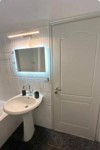 La salle de bains blanche est pourvue d'un lavabo et d'un miroir. dans l'établissement The lighthouse, à Chalcis