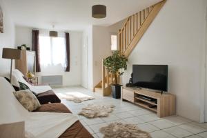 sala de estar con sofá y TV de pantalla plana en Beautiful 120m house, en Saint-Laurent-de-la-Salanque