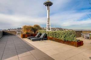 a patio with chairs and a clock tower in the background at Speechless In Seattle - #1 Location - 2BR - Free Parking - VR1 in Seattle