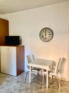 a dining room with a table and a clock on the wall at Il volto del lago - Rooms&Apartments in San Felice del Benaco