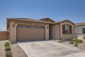 a house with a garage in front of it at NEW - 5BR Home 20 min from Phoenix - AT in Avondale