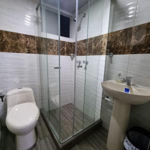 a bathroom with a toilet and a shower and a sink at Hotel San Marcos Las Lajas in Ipiales