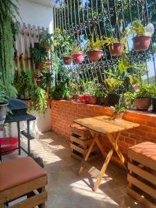 a patio with tables and potted plants on a wall at Bryslaungeguayaquil in Guayaquil