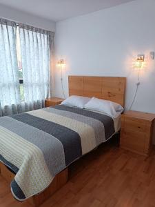 a bedroom with a bed and two lamps and a window at Casa de Campo LA COBIJA in Calca