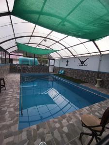 a large swimming pool with a green roof at Casa de Campo LA COBIJA in Calca