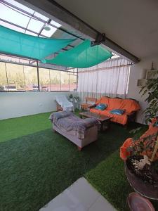 a living room with two couches and a green lawn at Casa de Campo LA COBIJA in Calca