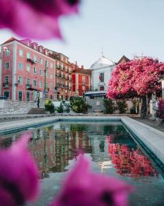 リスボンにあるAlfama Historical Apartmentsのピンクの花と建物の水のプール
