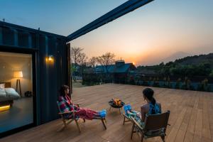 two girls sitting on a deck watching the sunset at Fujino Kirameki Fujigotemba in Gotemba