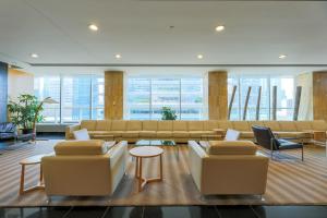 a living room with couches and tables and windows at Skyline Elegance Condo in Toronto