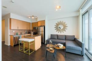 a living room with a couch and a kitchen at Skyline Elegance Condo in Toronto