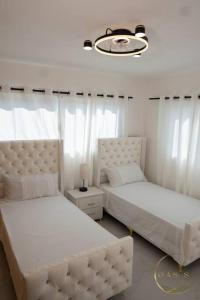 een slaapkamer met 2 bedden en een kroonluchter bij Apartamento en Playa Palenque in Puerto Palenque