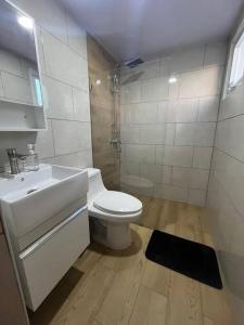een witte badkamer met een toilet en een wastafel bij Apartamento en Playa Palenque in Puerto Palenque