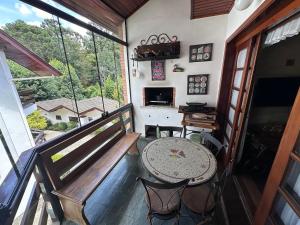 a balcony with a table and chairs in a room at Apartamento no centrinho para a família in Campos do Jordão