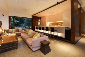 sala de estar con sofá y cocina en 6 Beachfront Mirage - Luxury 4 Bedroom Home, en Port Douglas