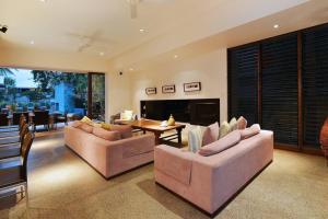una gran sala de estar con 2 sofás y una mesa. en 6 Beachfront Mirage - Luxury 4 Bedroom Home, en Port Douglas